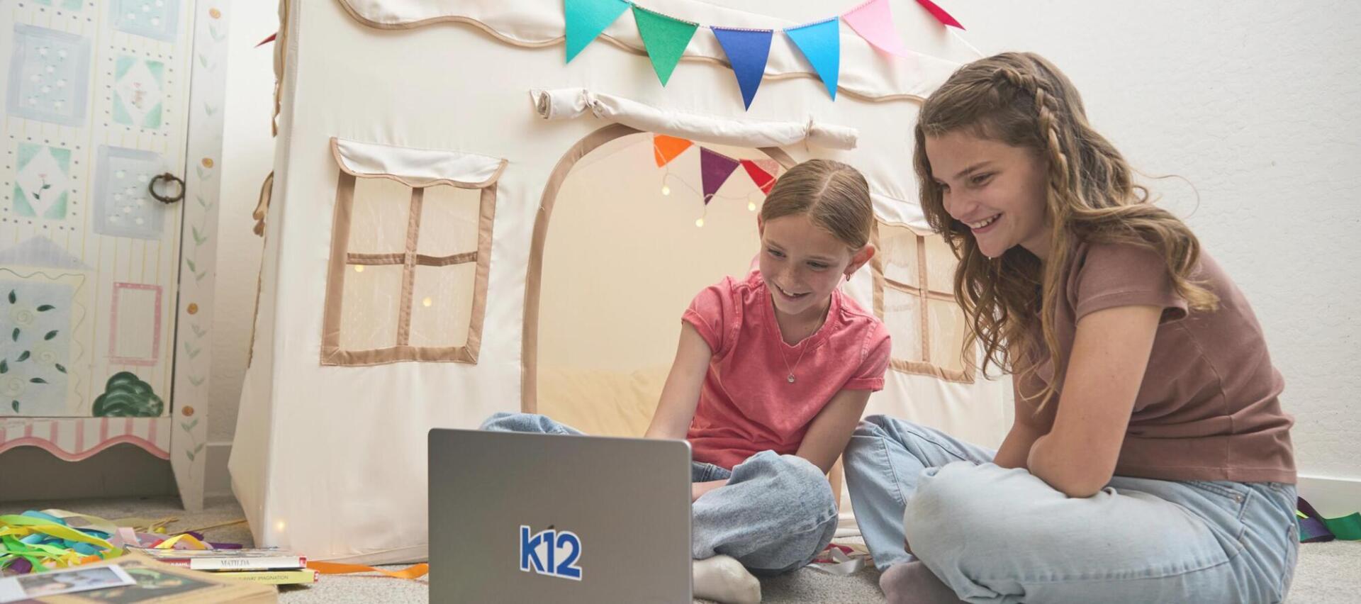 Mother and her daughter working together with their laptop at home