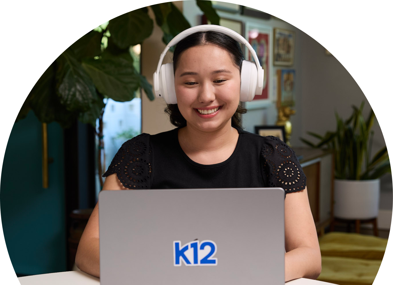 Student with her laptop wearing a white pair of headphones